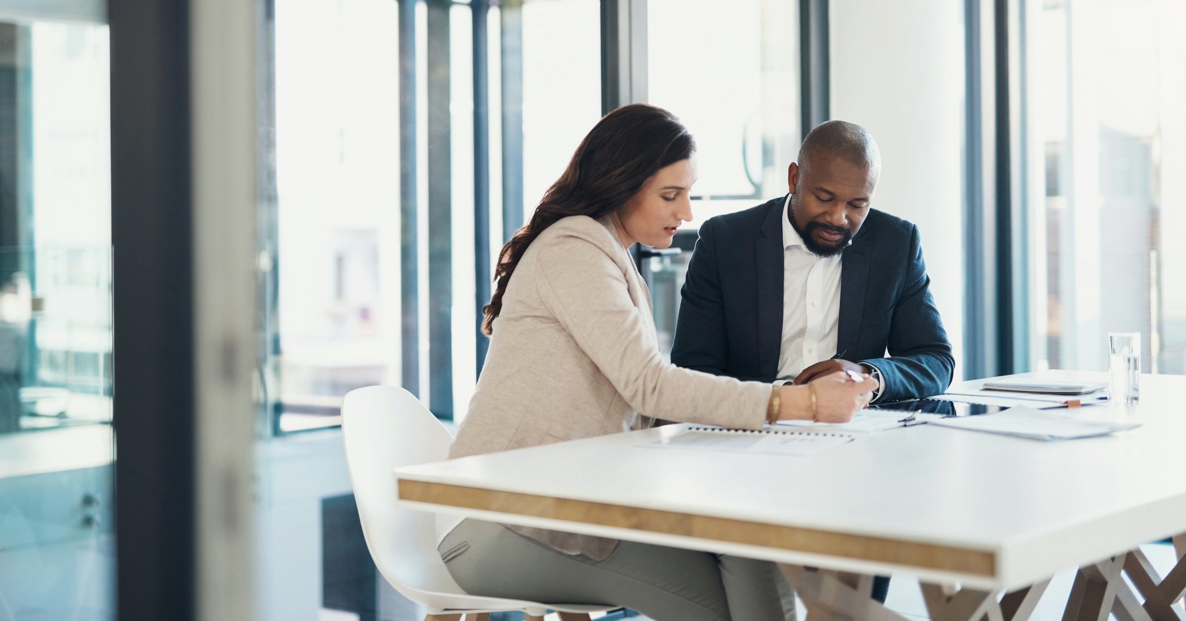 Two people in an office going over written material